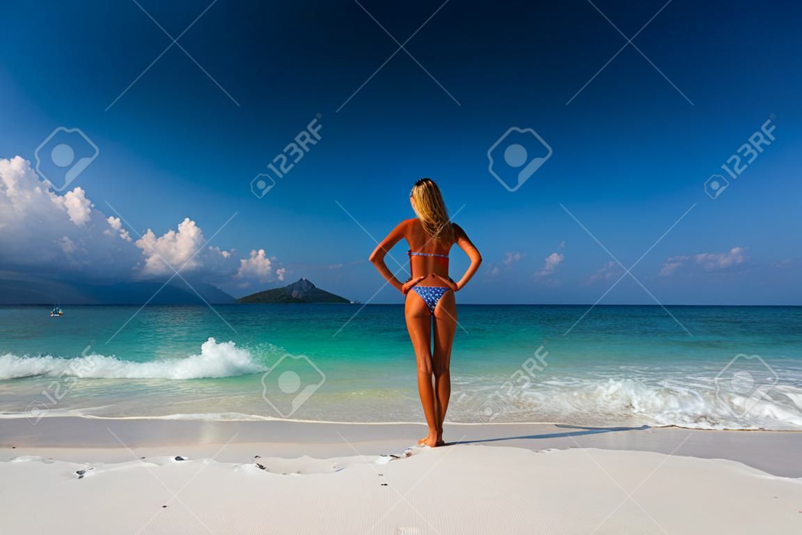 Junge Frau auf einem weißen Sandstrand stehen
