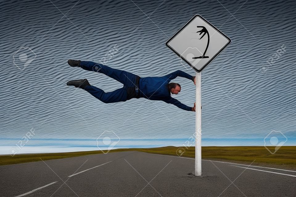 Man having fun with road sign set on the patagonian road in latitudes of Roaring Forties famous by its strong winds. Argentina