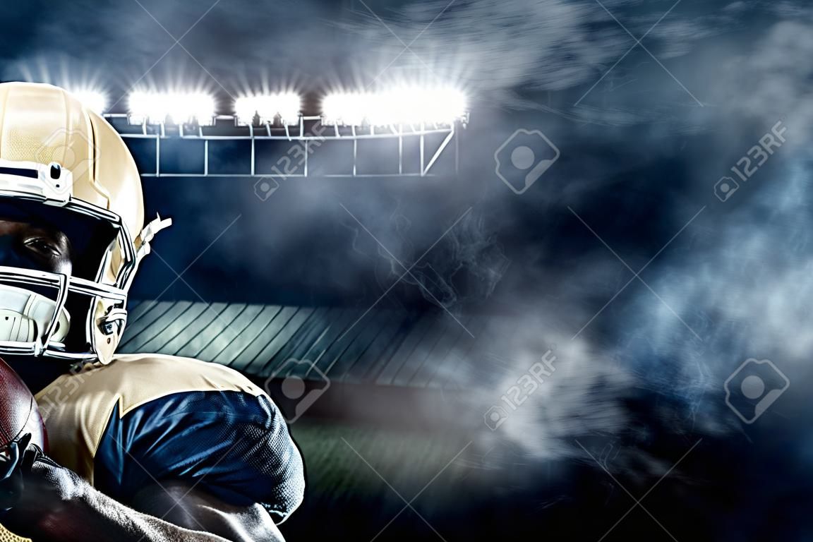Giocatore di football americano americano sullo stadio con luci sullo sfondo con spazio di copia