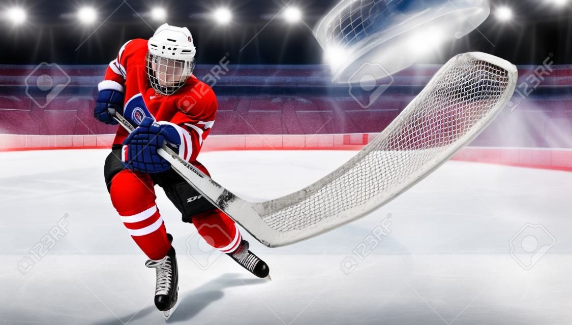 Athlète joueur de hockey sur glace dans le casque et les gants sur le stade avec bâton. Tir d'action. Notion sportive.