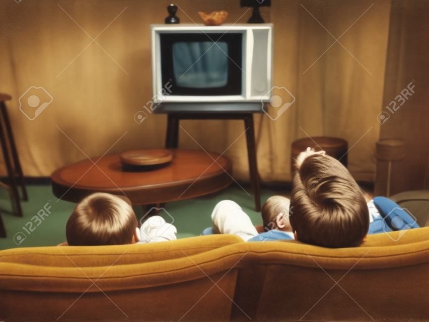 dois meninos assistindo televisão em casa no estilo dos anos 50, baleado por trás