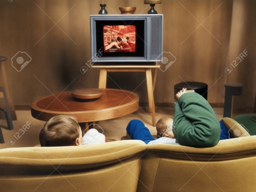 dois meninos assistindo televisão em casa no estilo dos anos 50, baleado por trás