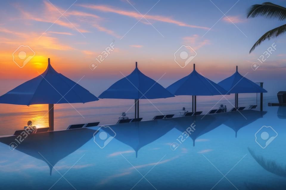 pool and umbrellas on the background of the sea and sky at dawn