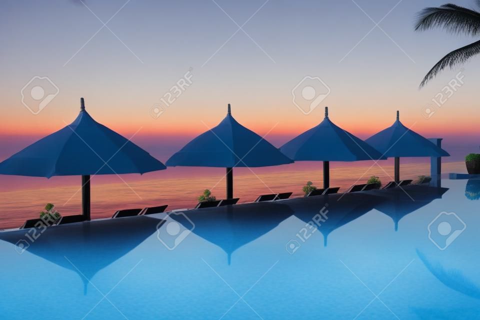 pool and umbrellas on the background of the sea and sky at dawn