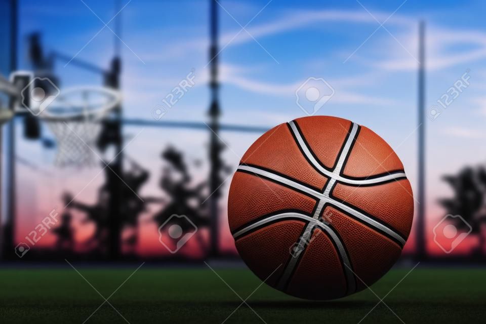 La pallacanestro giace a terra sullo sfondo del cielo serale. Sfondo sportivo