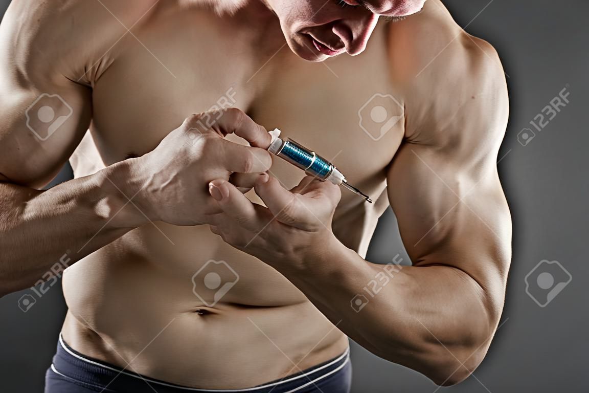 Close up of a muscular man injecting himself with steroids