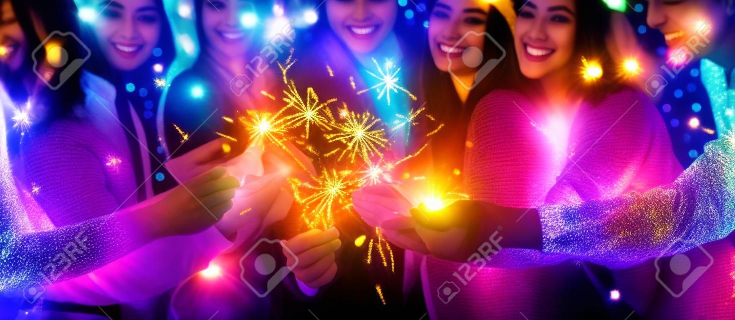 Gruppe glücklicher Freunde in Silvester mit funkelnden bengalischen Lichtern, Panorama, Nahaufnahme