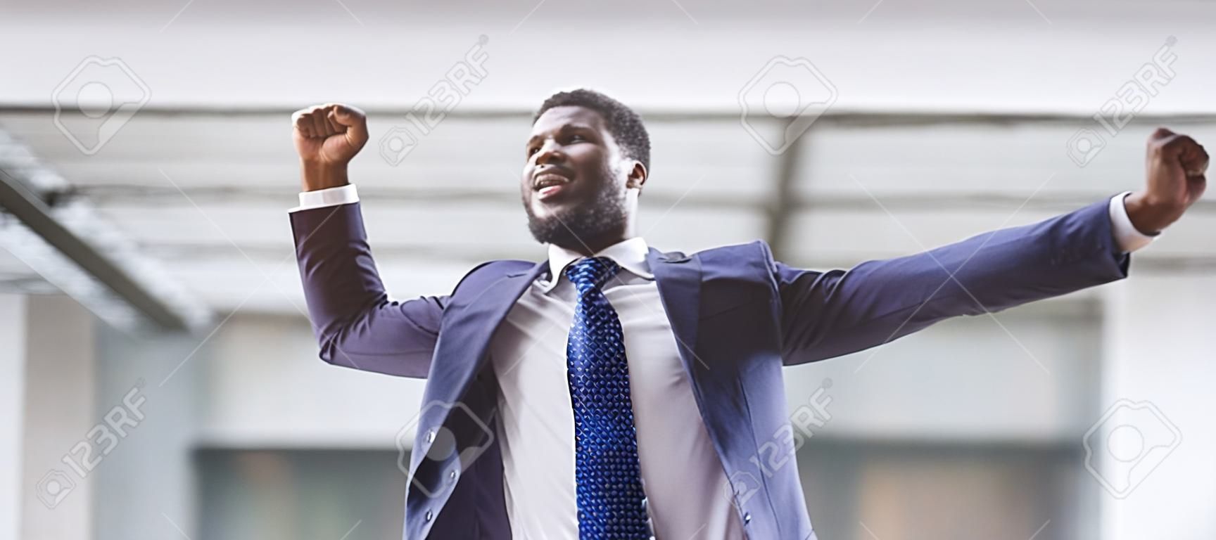 Handsome African American Guy Shaking Clenched Fists Celebrating Business Success. Panorama with free space