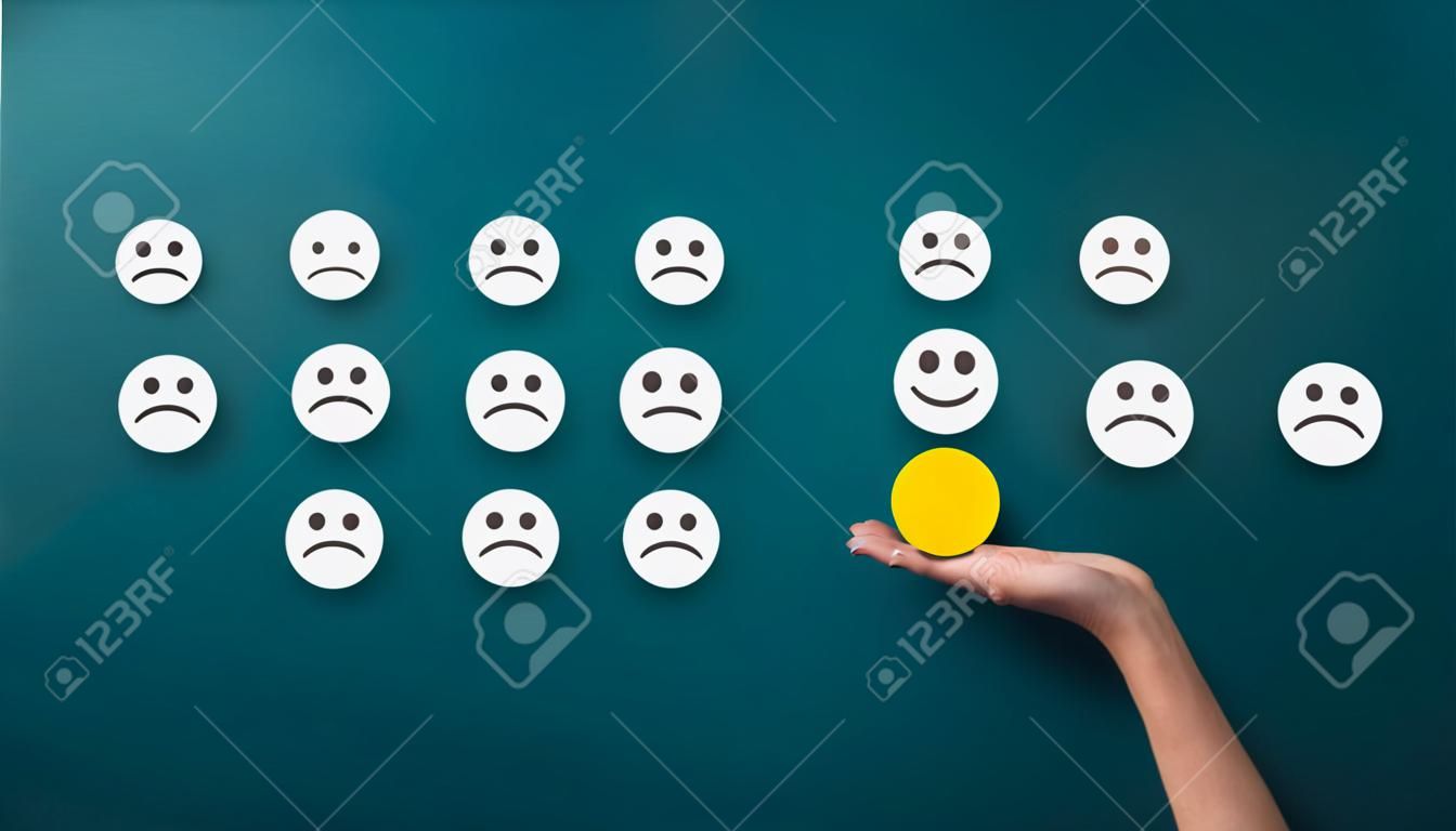 Rating concept. Woman choosing happy smiley face emotion on green background, panorama, copy space