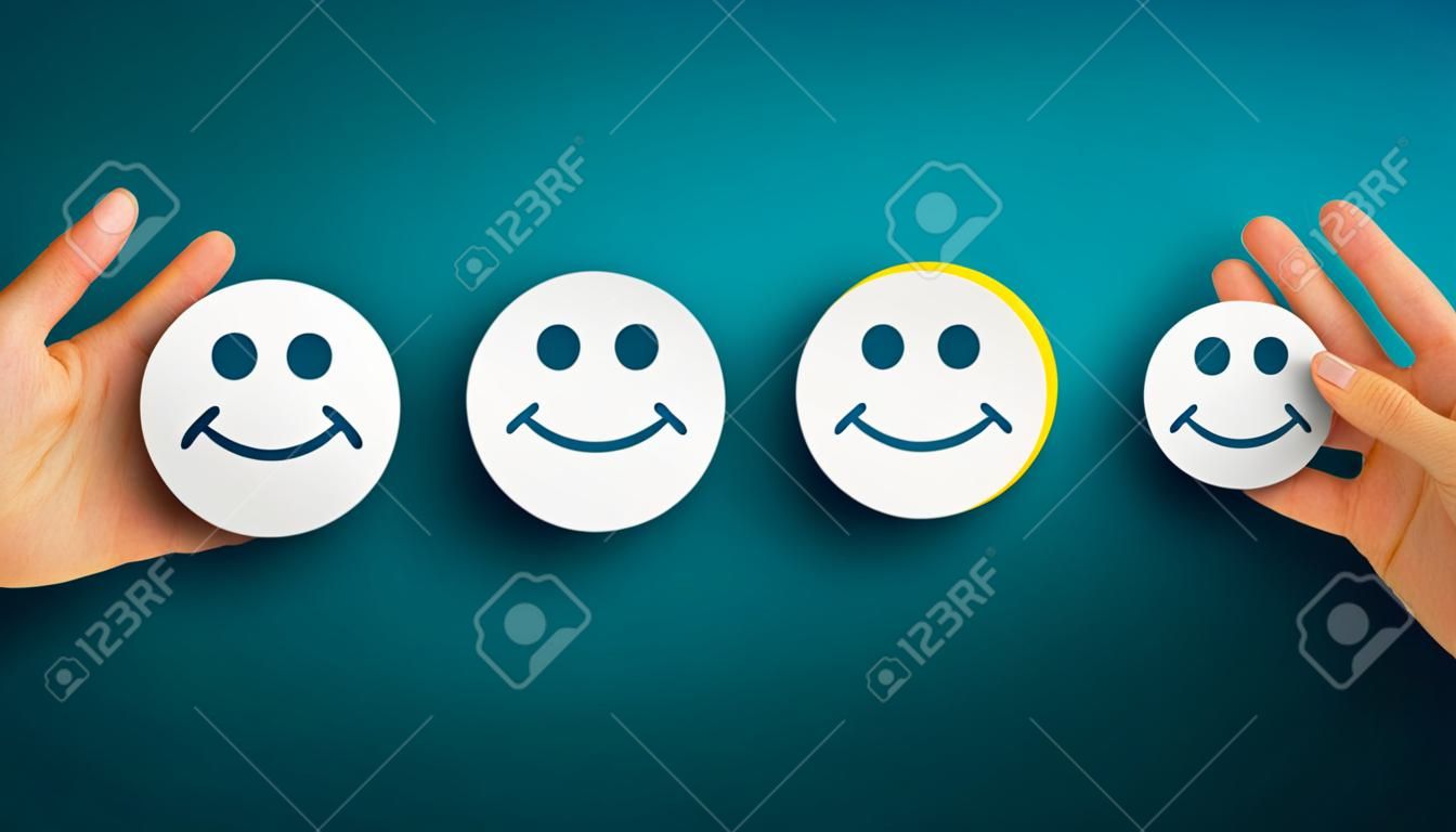 Choisissez à la main l'icône de sourire heureux sur fond bleu, panorama, espace de copie. Concept d'évaluation du service client et d'enquête de satisfaction