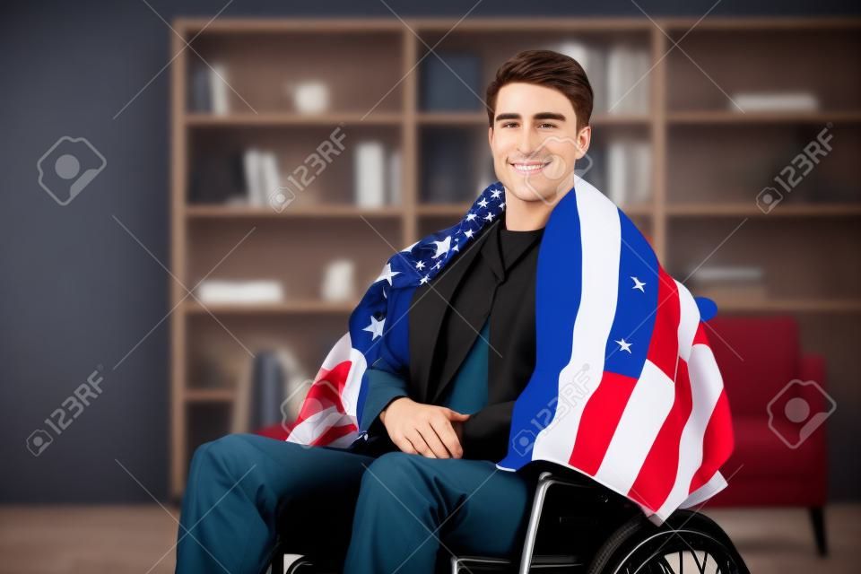 Handsome military guy in wheelchair with flag of the US