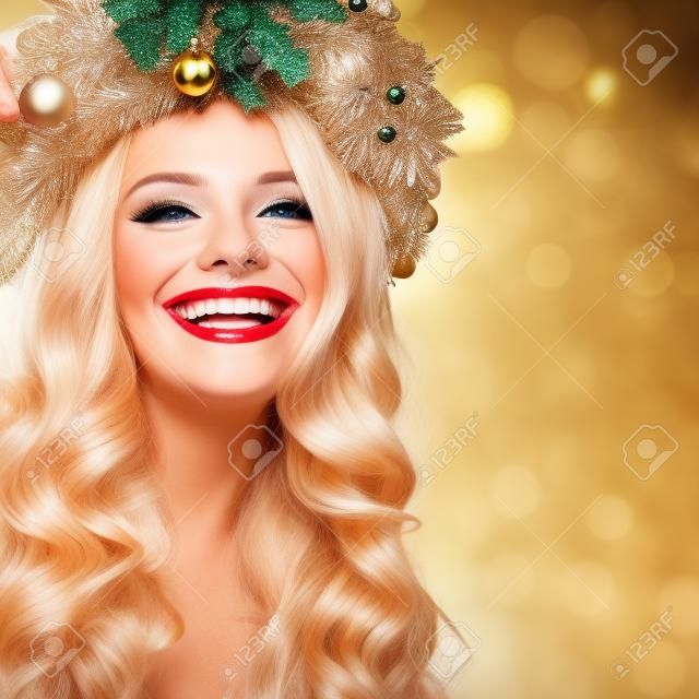 クリスマスや新年の美しさ。ブロンドの髪とメイクが笑っている笑顔のモデルの女性。パーティーの背景に金髪の巻き毛のヘアスタイルの少女