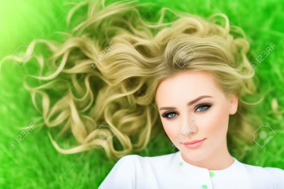 Beautiful summer woman on green grass outdoors