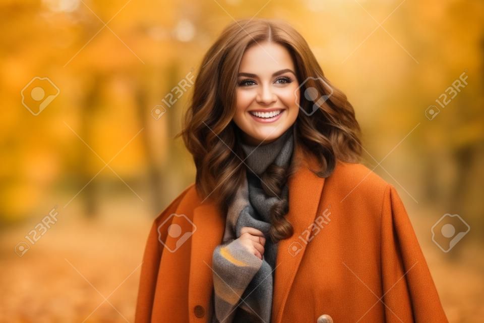 Ritratto di donna castana sorridente in autunno