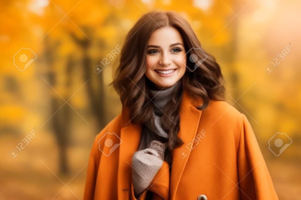 Portret uśmiechniętej brunetki kobiety jesienią