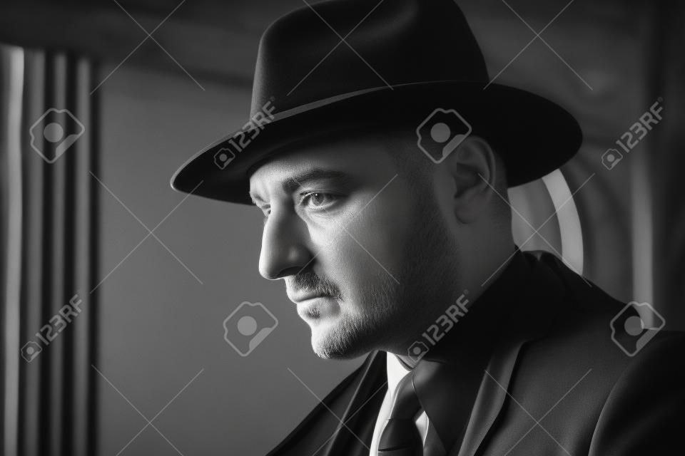 Zwart-wit portret van een man in een pak en hoed