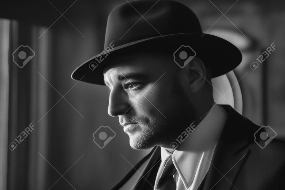 Zwart-wit portret van een man in een pak en hoed
