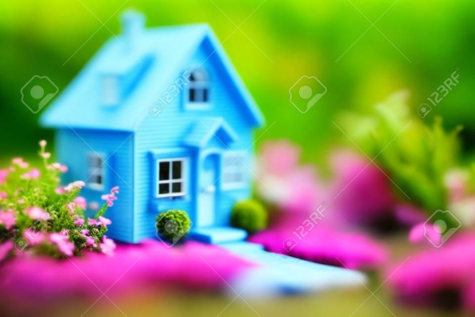 Miniature house in the garden. Real estate concept. Selective focus.