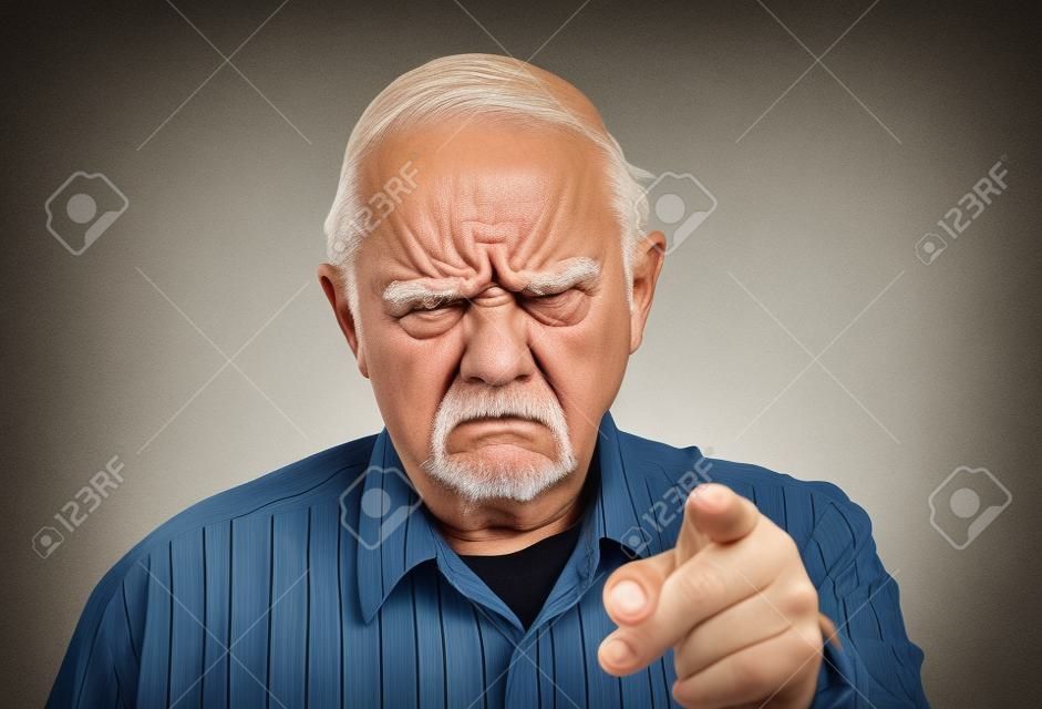 脾气暴躁的老人或老人用手指对着摄像机，皱着眉头，责备或警告你。