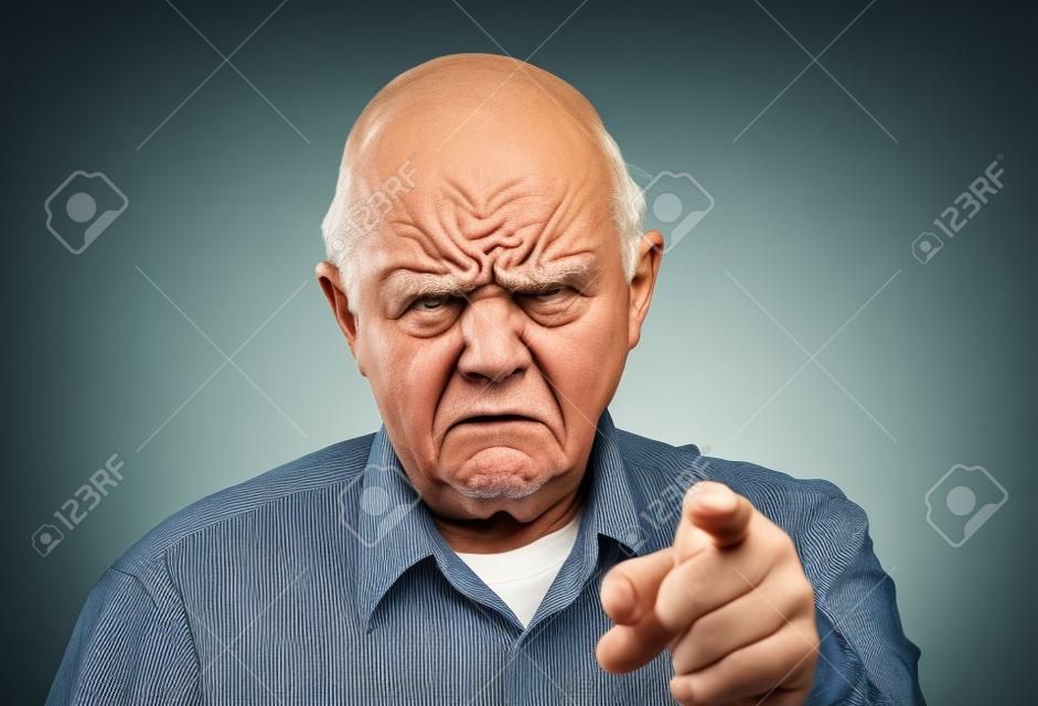 Grumpy homme en colère supérieur ou vieux pointant son doigt vers la caméra avec un froncement de sourcils grand sur son visage, de blâmer ou pour vous avertir.