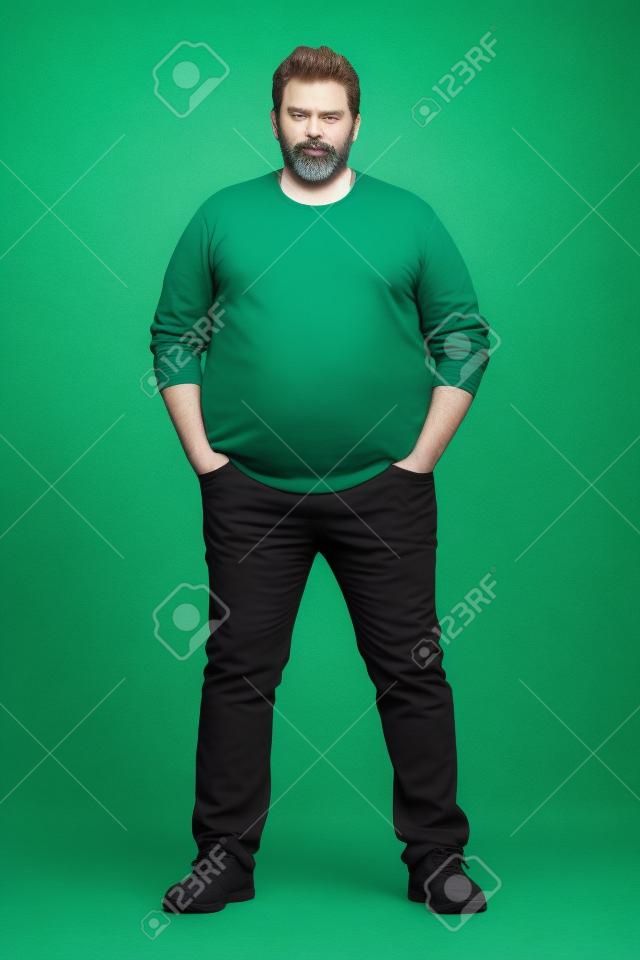 Complete body shot of a big guy looking at camera, real ordinary middle age bearded white man with weight problem in front of green screen, can be actor or extra.