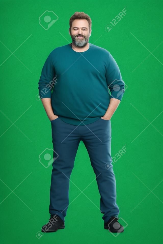 一个大块头的身体完整的镜头看着镜头，真正普通的中年胡子男人，体重问题在绿色屏幕前可以演员或额外的。