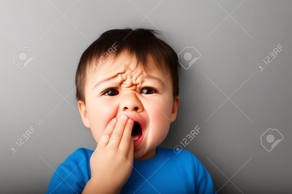Маленький мальчик расстроен или больно, зубная боль или другой гадостей концепция.