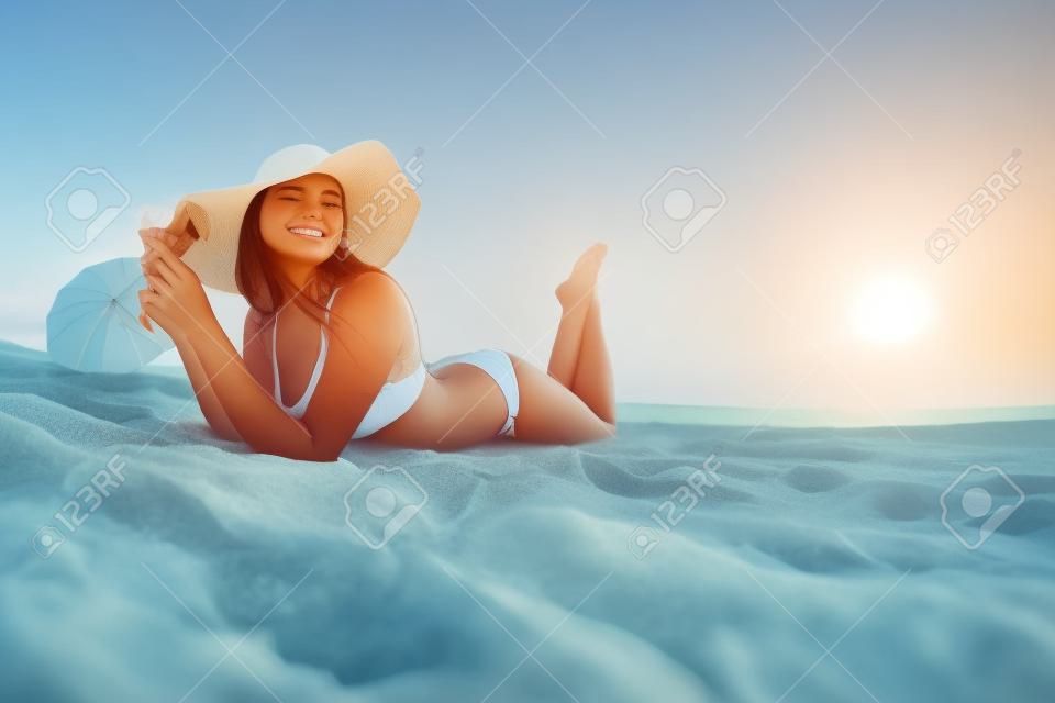 Женщина на пляже. Молодая красивая девушка на песке на берегу моря.