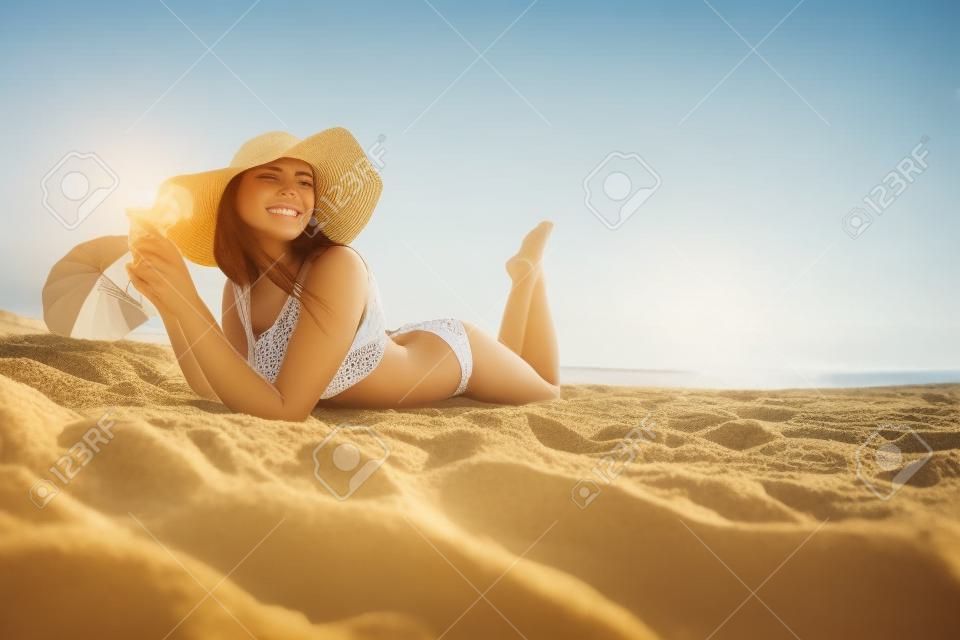 Женщина на пляже. Молодая красивая девушка на песке на берегу моря.