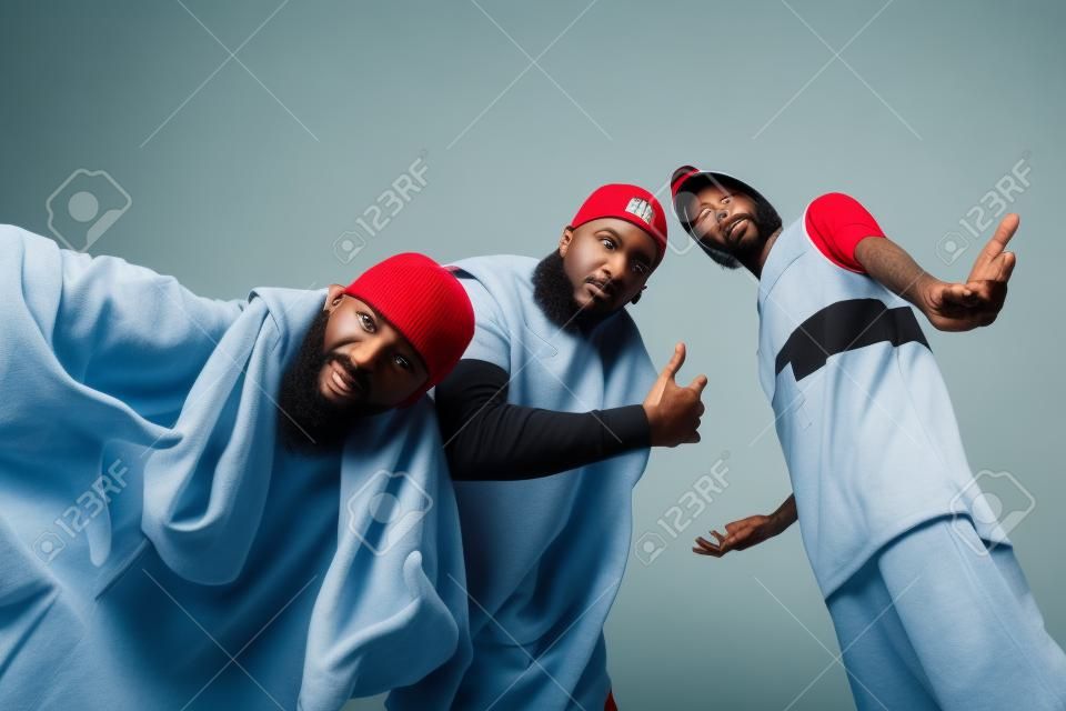 Gruppe von drei Rapper posiert im Fotostudio auf weißem Hintergrund
