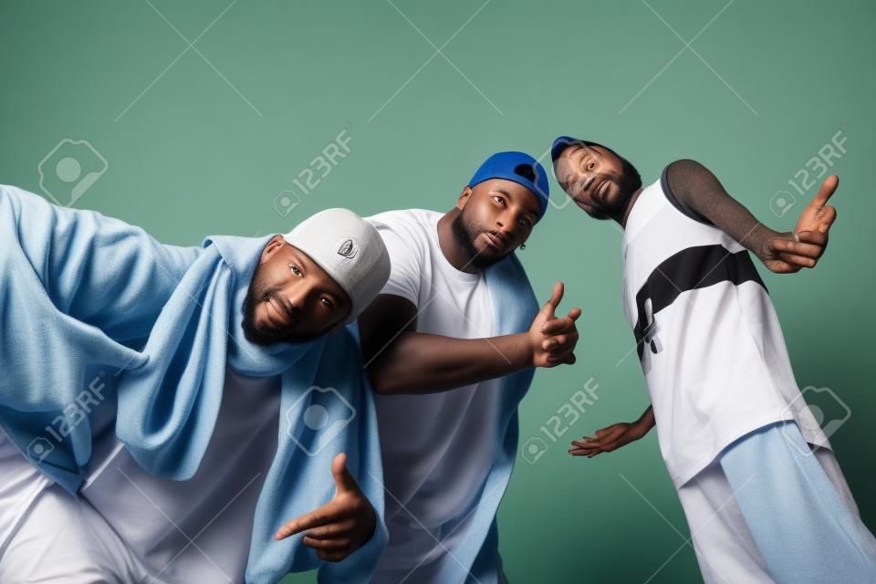 Gruppe von drei Rapper posiert im Fotostudio auf weißem Hintergrund