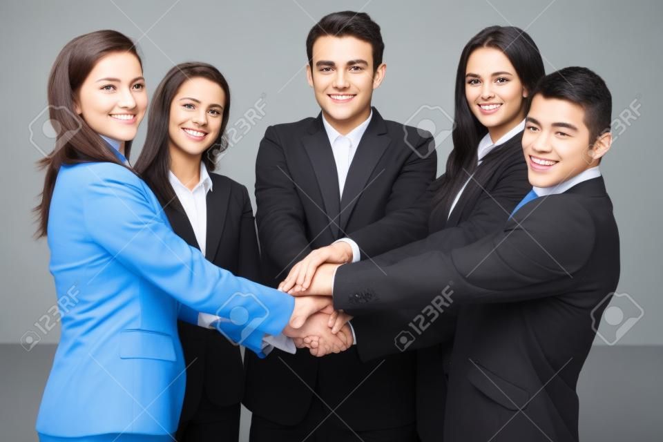 Equipo de 5 personas de negocios joven y feliz, tiene las manos juntas