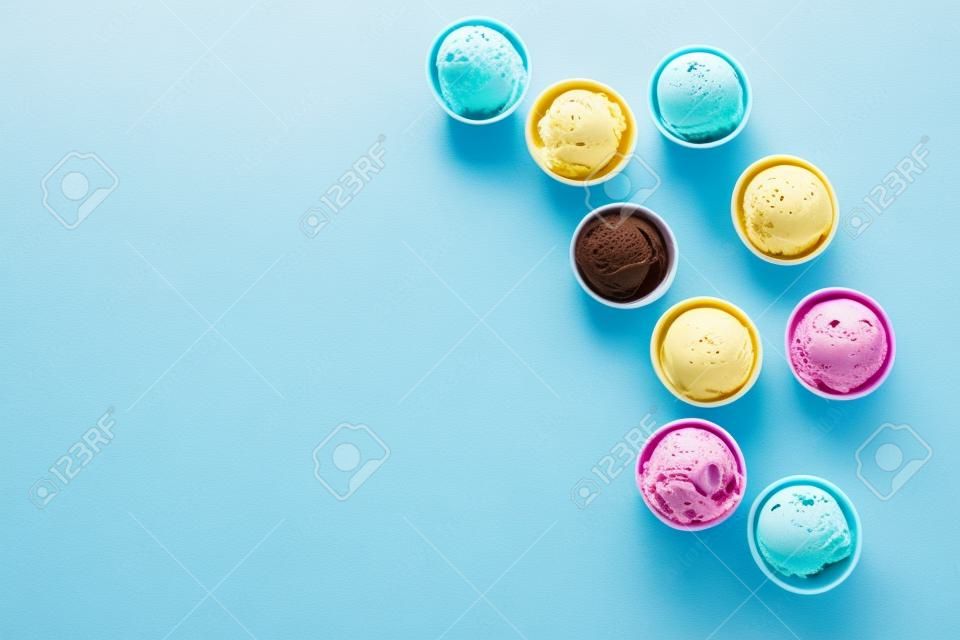 Sortimento de sorvete. Vários sorvetes ou gelato no fundo azul, espaço de cópia. Iogurte congelado em pequenas xícaras - sobremesa de verão saudável.