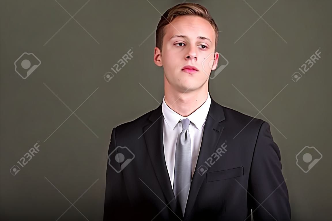 Young handsome businessman wearing suit against colored backgrou