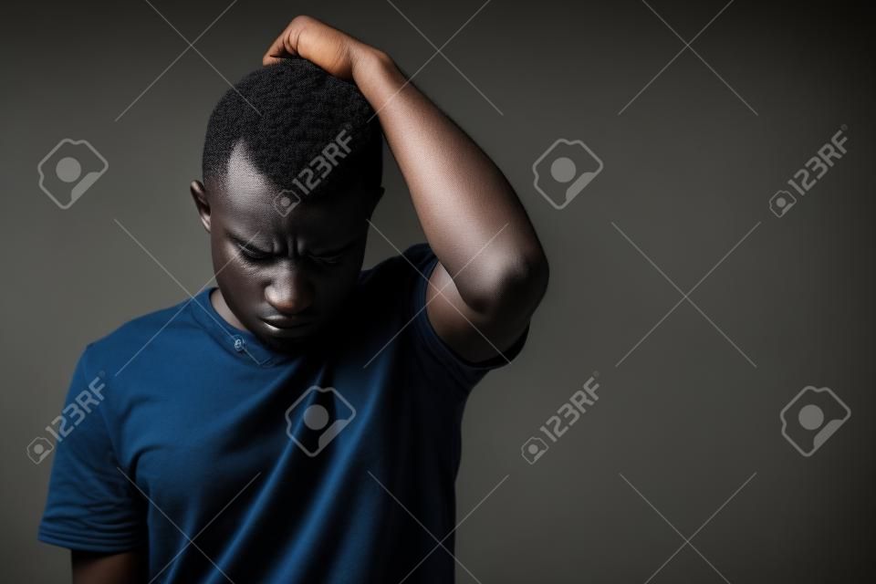 Sad young African man thinking and looking depressed