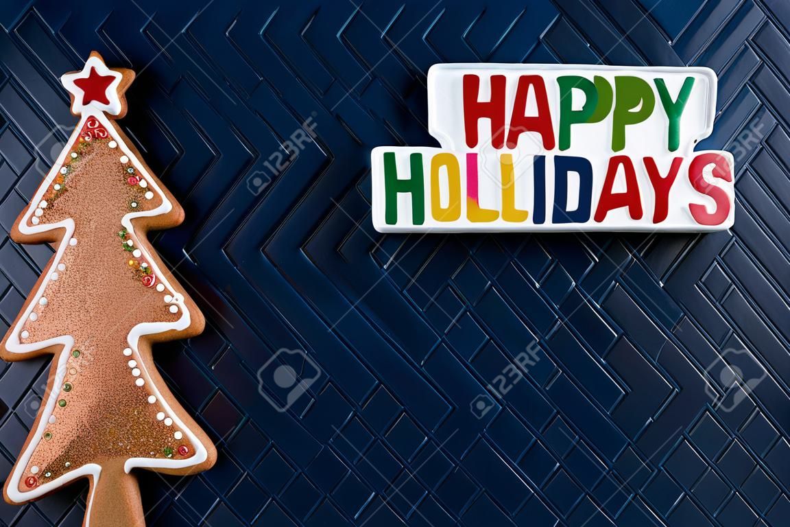 Happy Holidays plaque message and a glitter gingerbread Christmas Tree on blue background