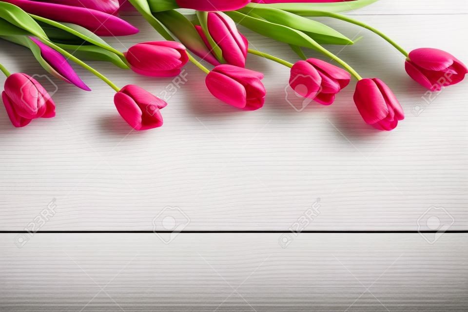 Colorful tulips on white wooden table with copy space