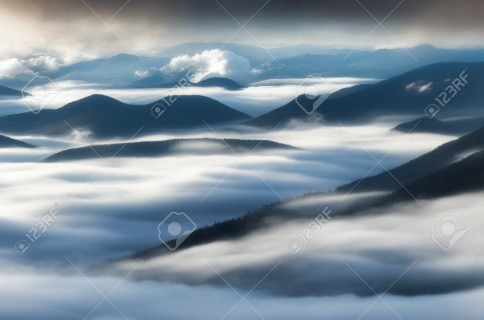 Vales de montanha misty cobertos com nuvens. Incrível vista para a montanha