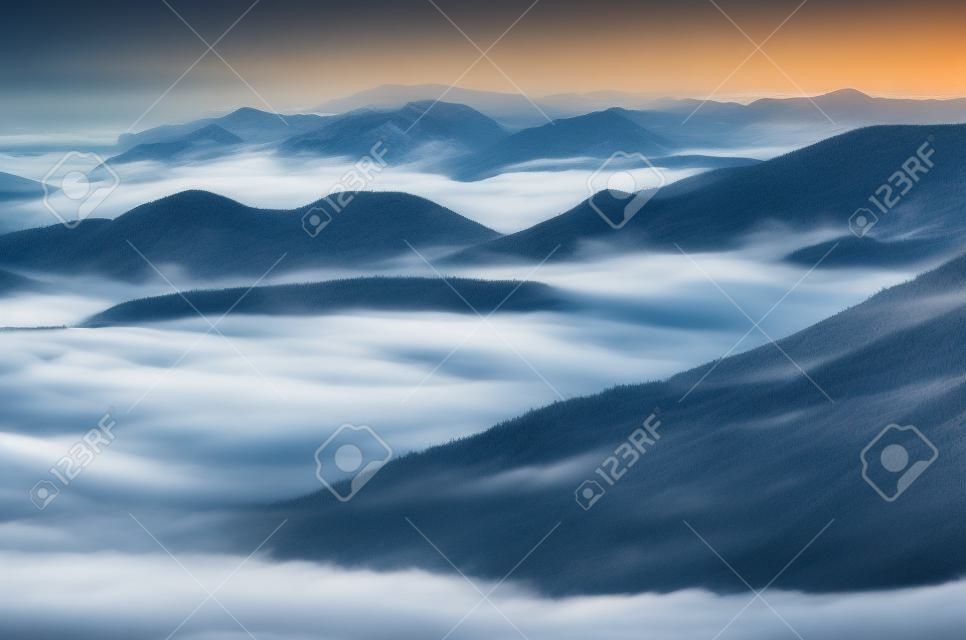 Vales de montanha misty cobertos com nuvens. Incrível vista para a montanha