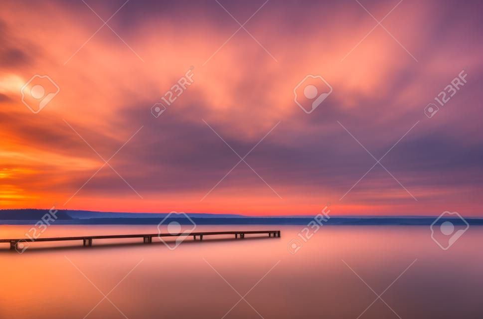 Old wooden pier on a lake at sunrise