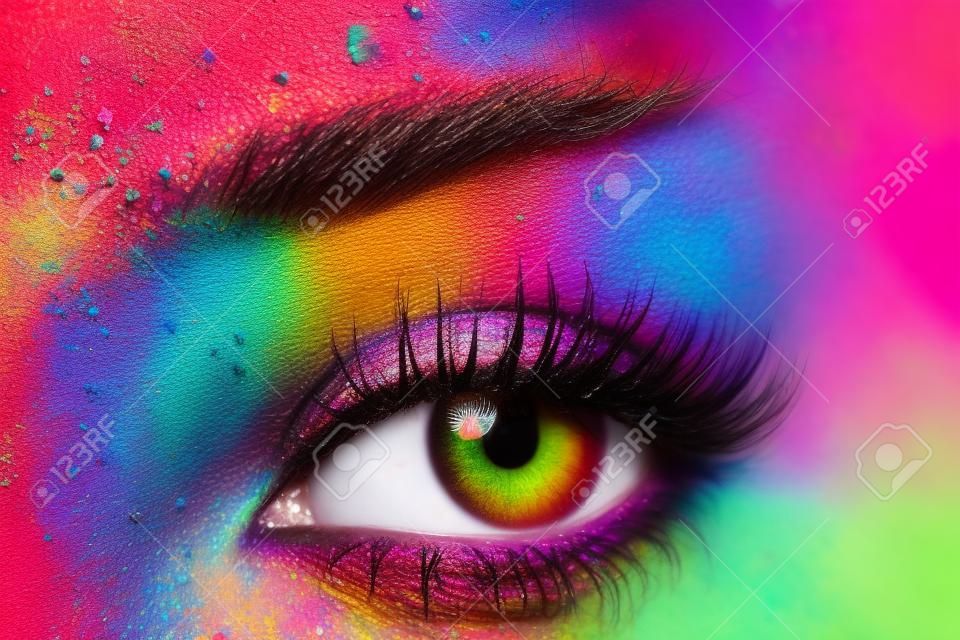 Primo piano vista di occhio femminile con brillante moda trucco multicolore. Holi Festival colore indiano ispirato. macro shot Studio