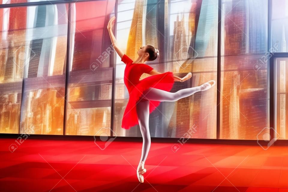 Eine junge Ballerina in einem knallroten Tutu tanzt vor dem Hintergrund einer Stadtlandschaft