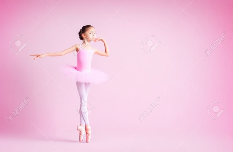 Kleine Ballerina-Tänzerin in einem rosa Ballettröckchen-Akademiestudenten, der auf weißem Hintergrund aufwirft