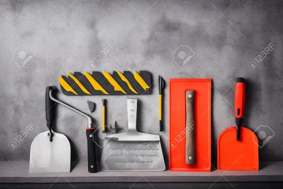 Construction tools on concrete background. Copy space for text. Set of assorted plaster trowel tools and spatula .