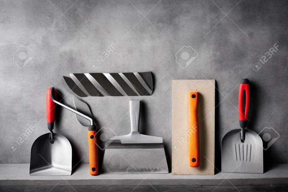 Construction tools on concrete background. Copy space for text. Set of assorted plaster trowel tools and spatula .