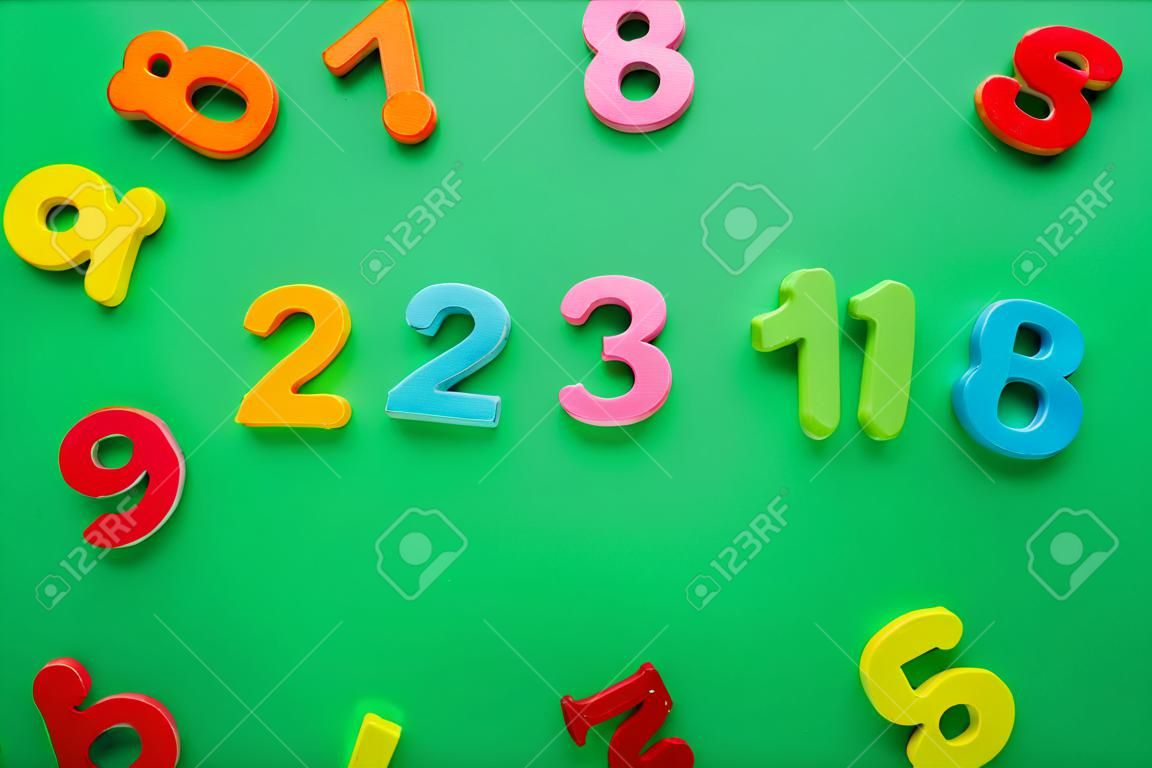 Magnetic multi-colored numbers on green background. Back to school. Top view.