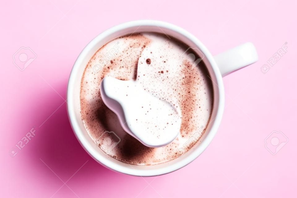 Chocolate caliente en una taza de cerámica rosa aislado en blanco desde arriba.