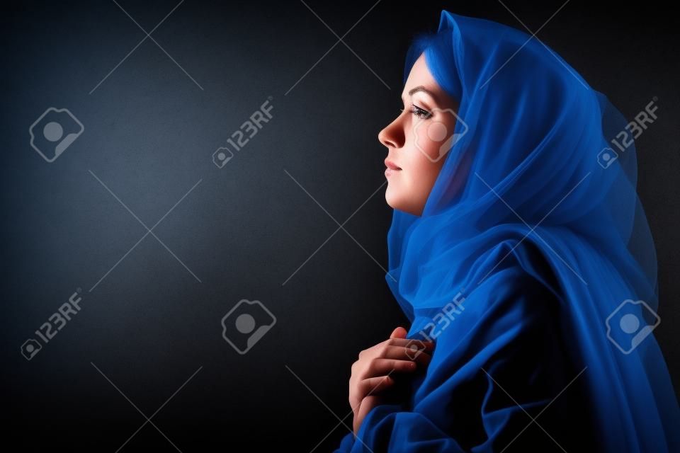 Virgen María con el velo azul Orando en el fondo Negro