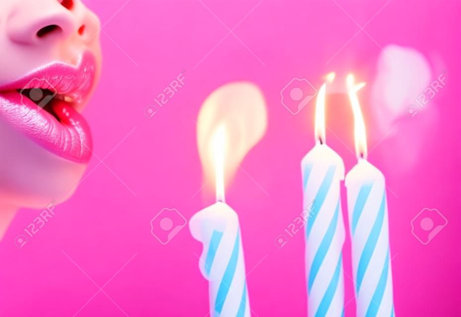 close-up de lábios soprando velas rosa