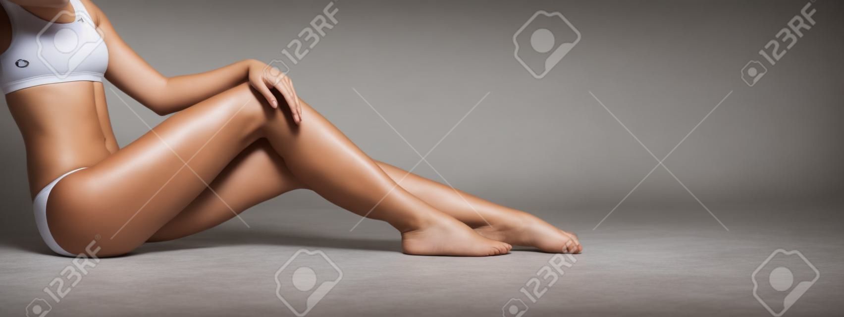Schöne Beine eines sportlichen Mädchens in Unterwäsche, schöne und gesunde Frau, die im Studio posiert, Sport, Fitness, Diät, Gewichtsverlust und Gesundheitskonzept